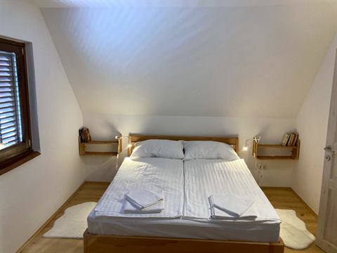 Erstes Schlafzimmer mit Doppelbett unter der Dachschräge