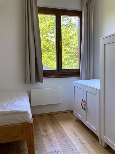 Drittes Schlafzimmer mit Bett und Fenster ins Grüne
